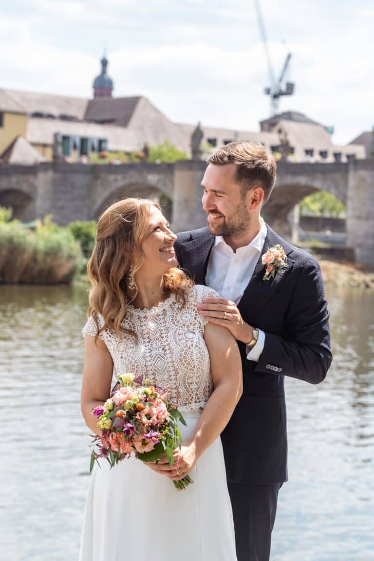 00903-florian-knusper-hochzeitsfotograf-wuerzburg-brautpaar-am-flussufer-Schlosshotel Steinburg Wuerzburg