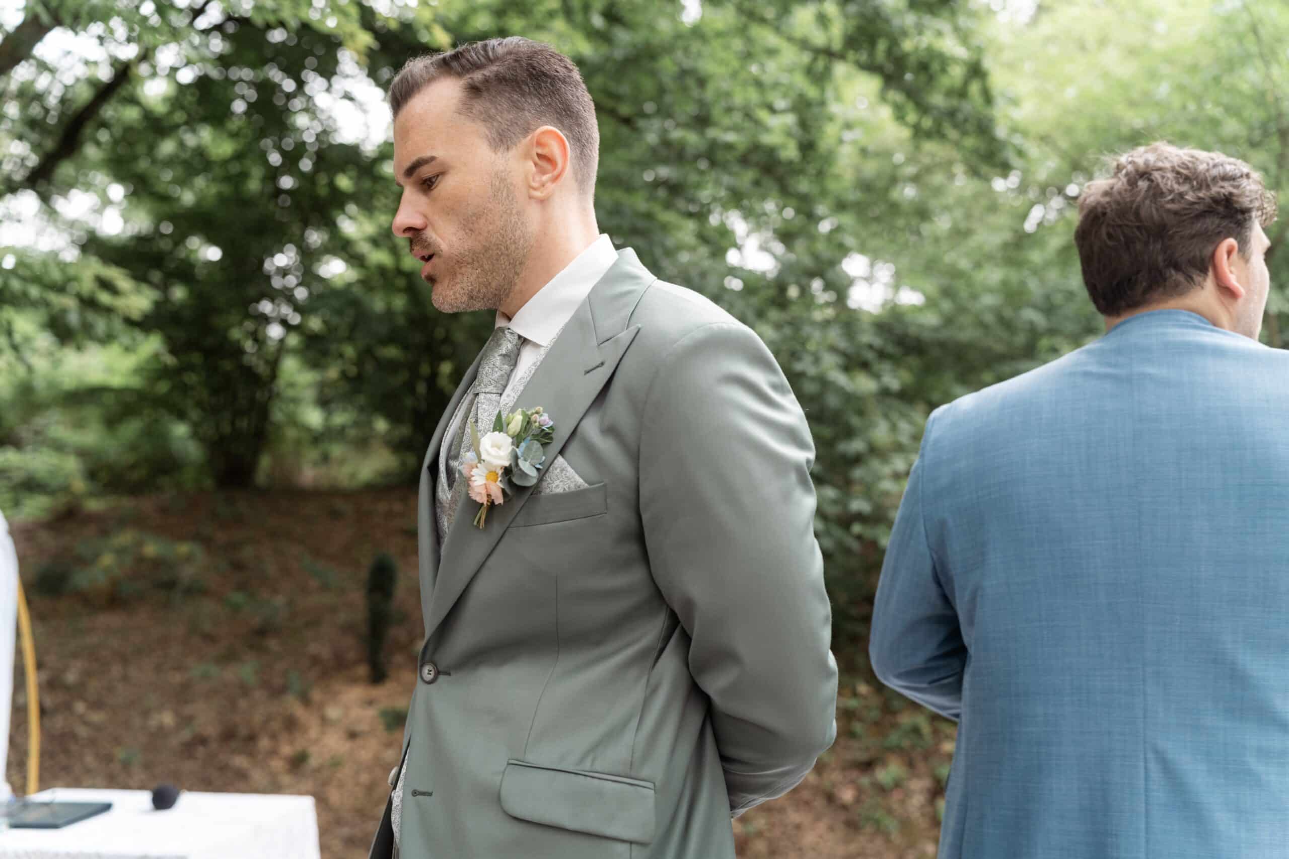 Gäste in eleganter Hochzeitskleidung im Park