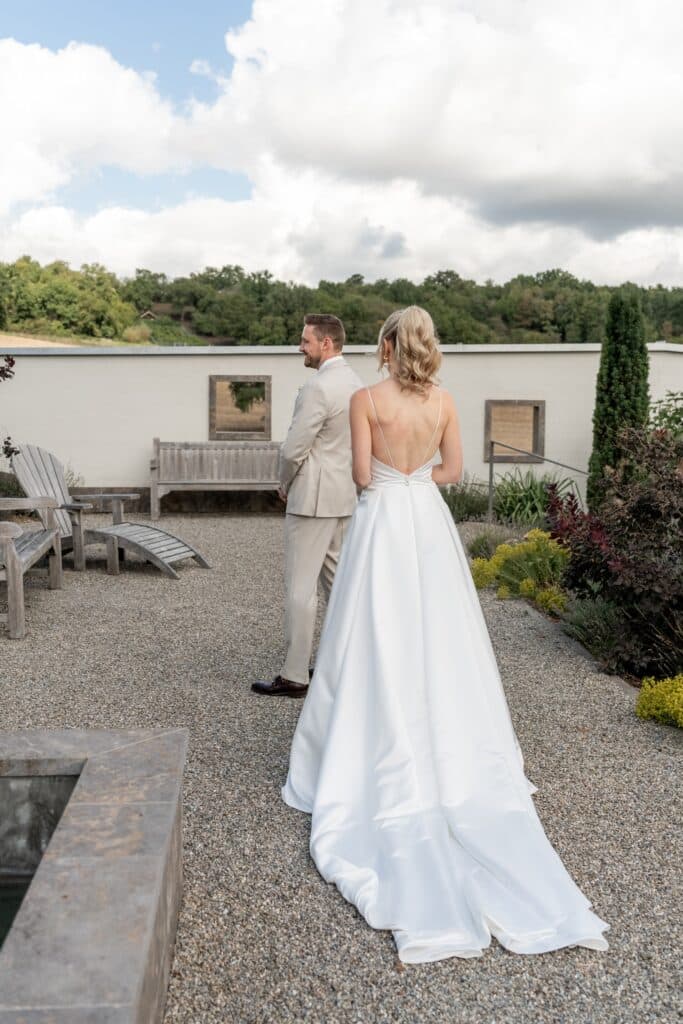 Hochzeitspaar im Garten mit Kiesweg und Holzbank