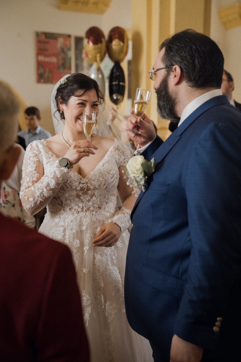 01278-florian-knusper-hochzeitsfotograf-wuerzburg-brautpaar-mit-sektglaesern-Schloss Oberschwarzach