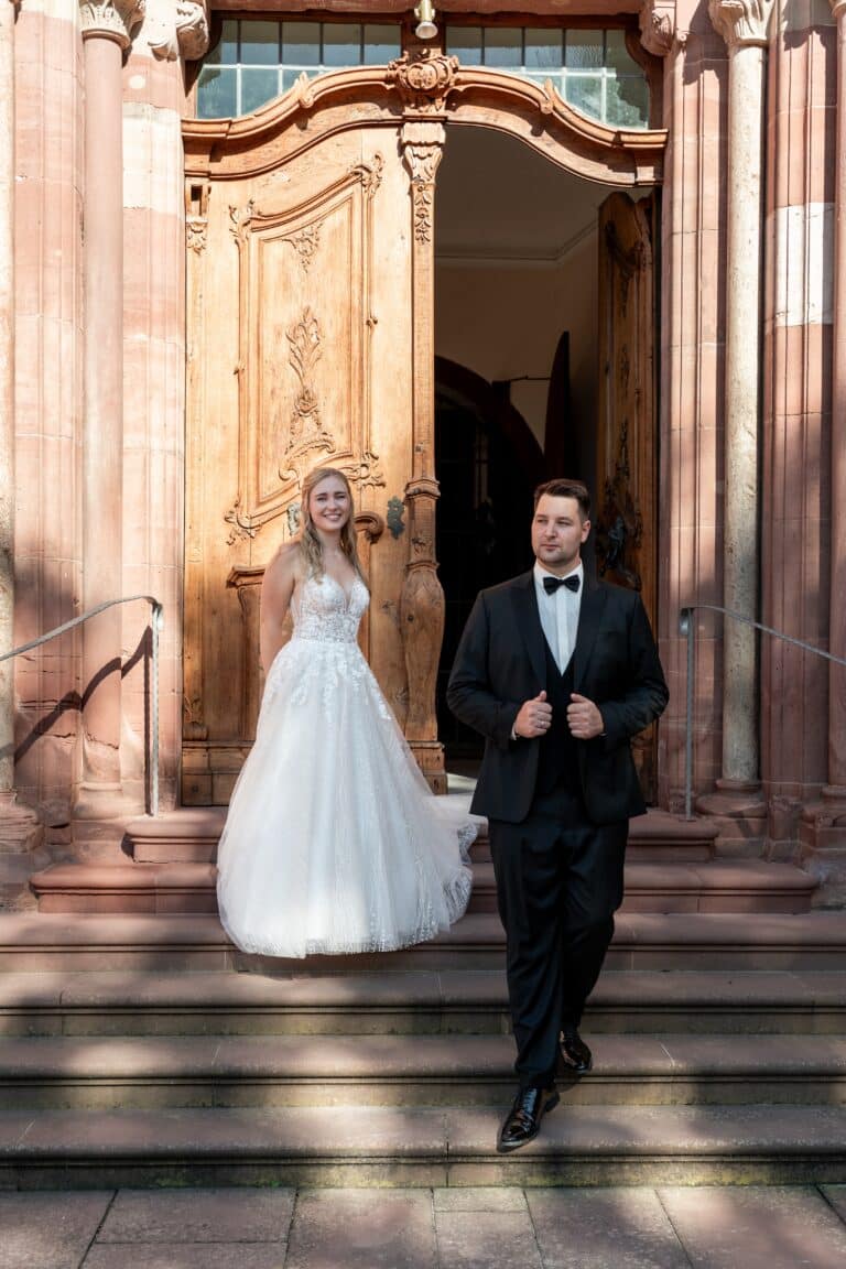 01386-florian-knusper-hochzeitsfotograf-wuerzburg-brautpaar-vor-kirchentuer-Kloster Bronnbach