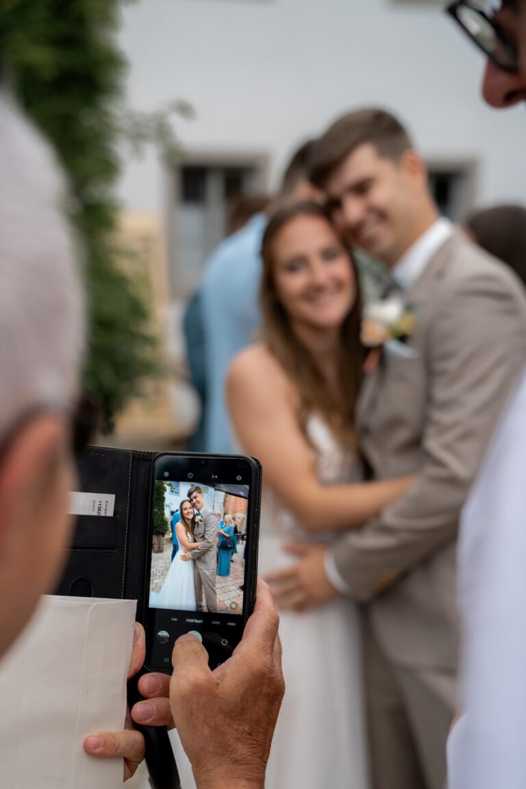 01412-florian-knusper-hochzeitsfotograf-wuerzburg-brautpaar-mit-handyaufnahme-Hotel Freihof Prichsenstadt