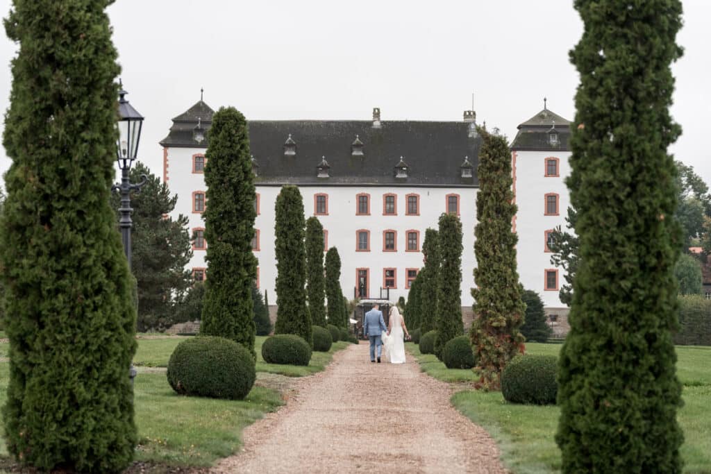 Brautpaar spaziert durch Schlossgartenallee