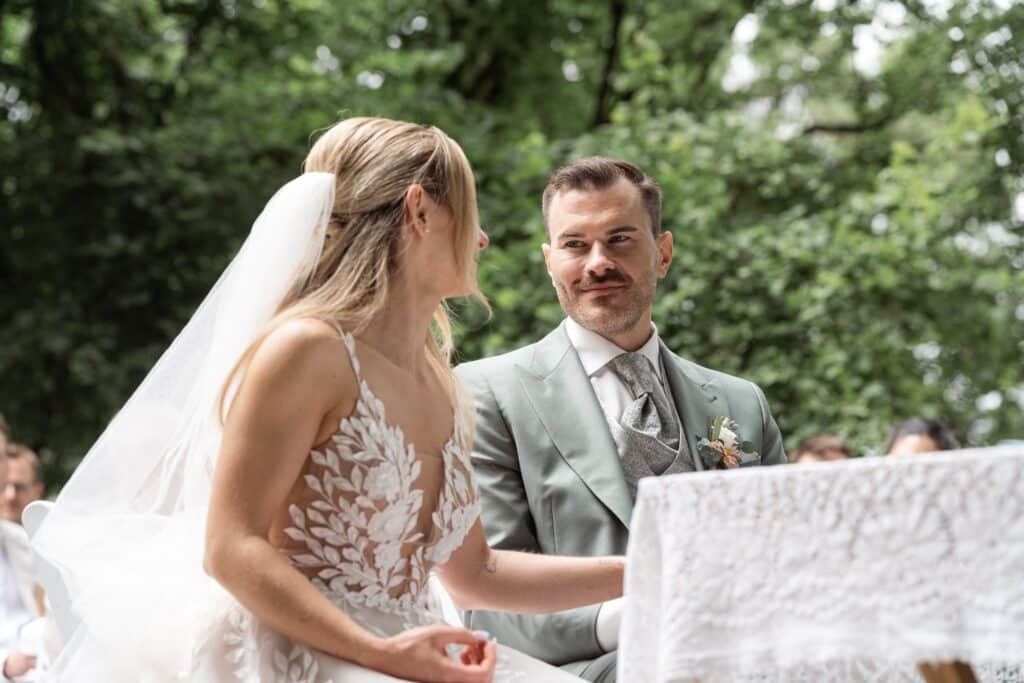 Brautpaar lächelnd beim Hochzeitsempfang im Freien