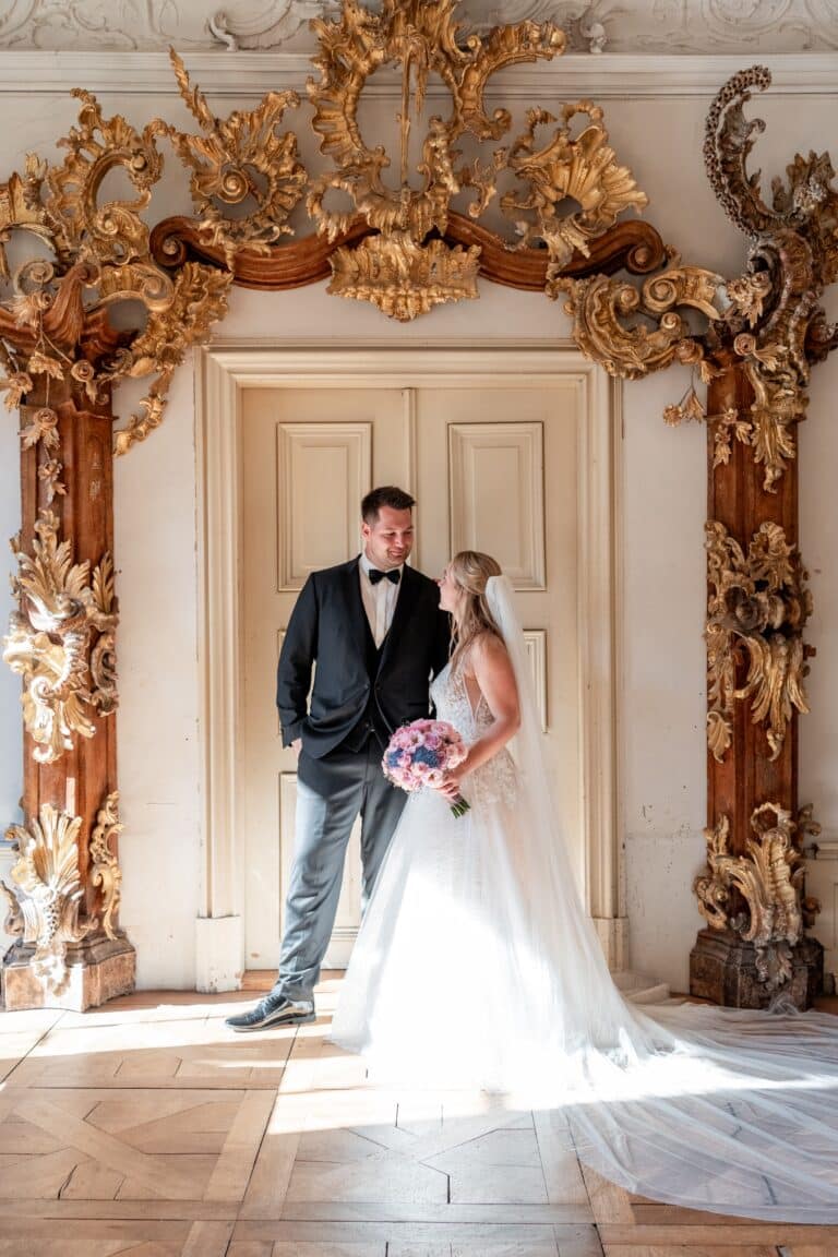 01612-florian-knusper-hochzeitsfotograf-wuerzburg-brautpaar-vor-verzierter-tuer-Kloster Bronnbach
