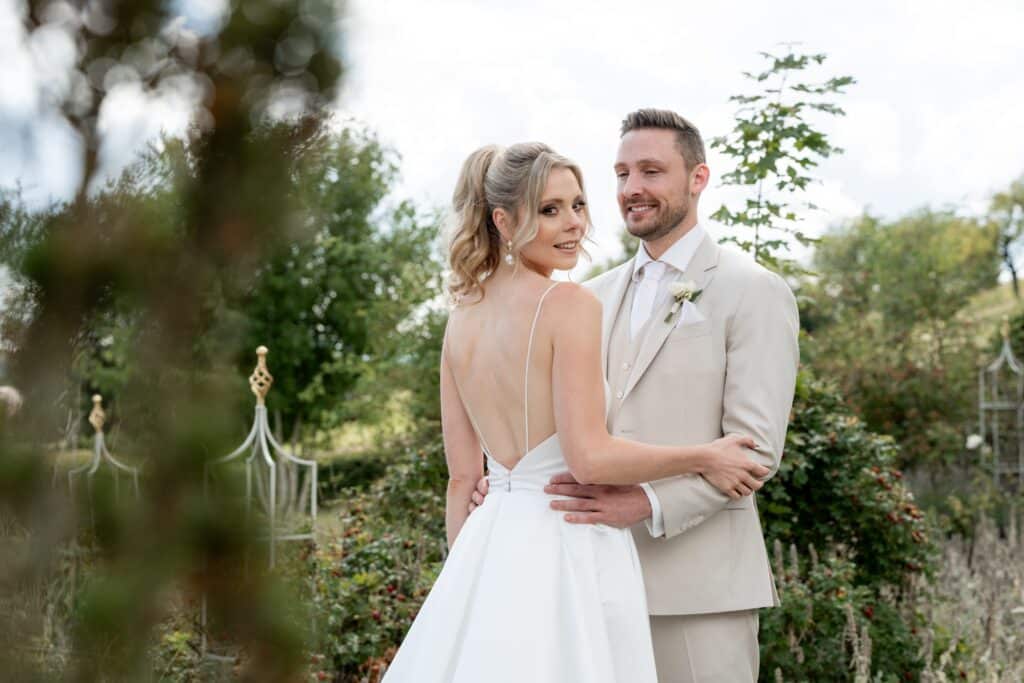 Brautpaar lächelt im Garten bei der Hochzeit