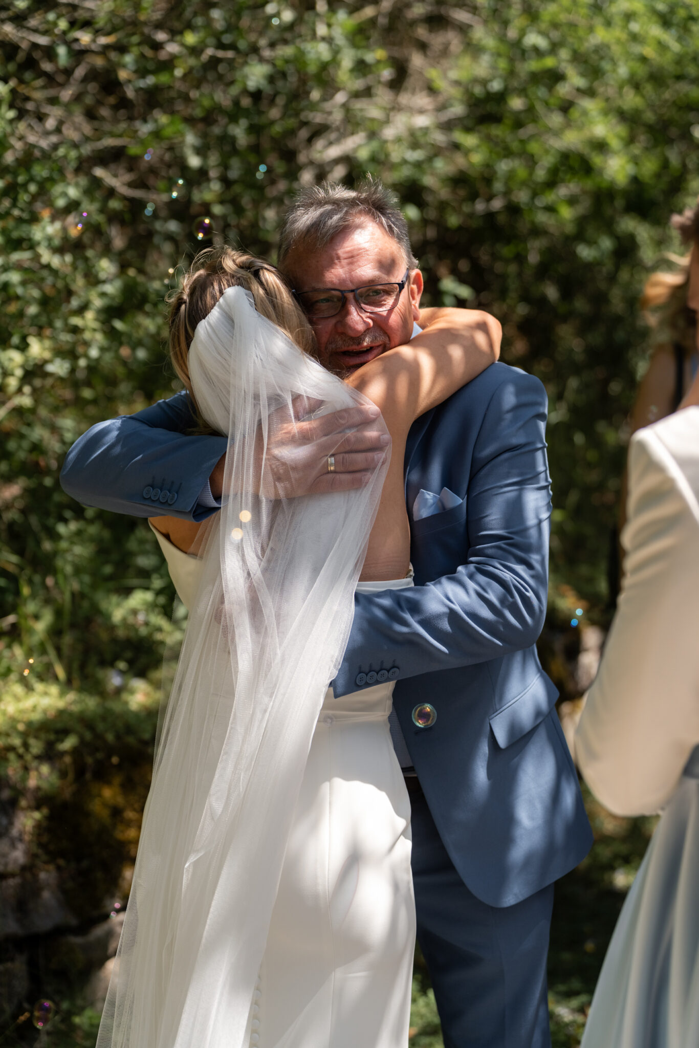 Braut umarmt Gast bei Gartenhochzeit