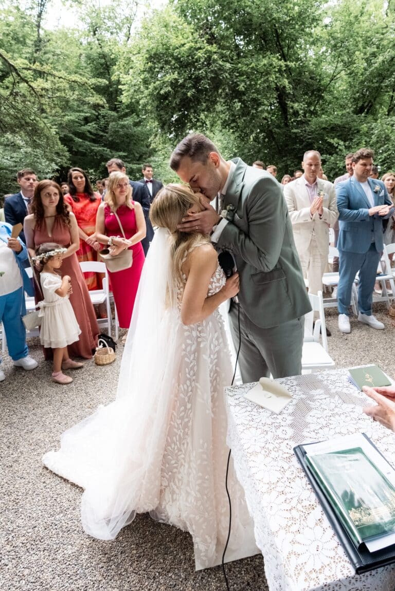 01699-florian-knusper-hochzeitsfotograf-wuerzburg-brautpaar-kuss-vor-gaesten-villa-oriental