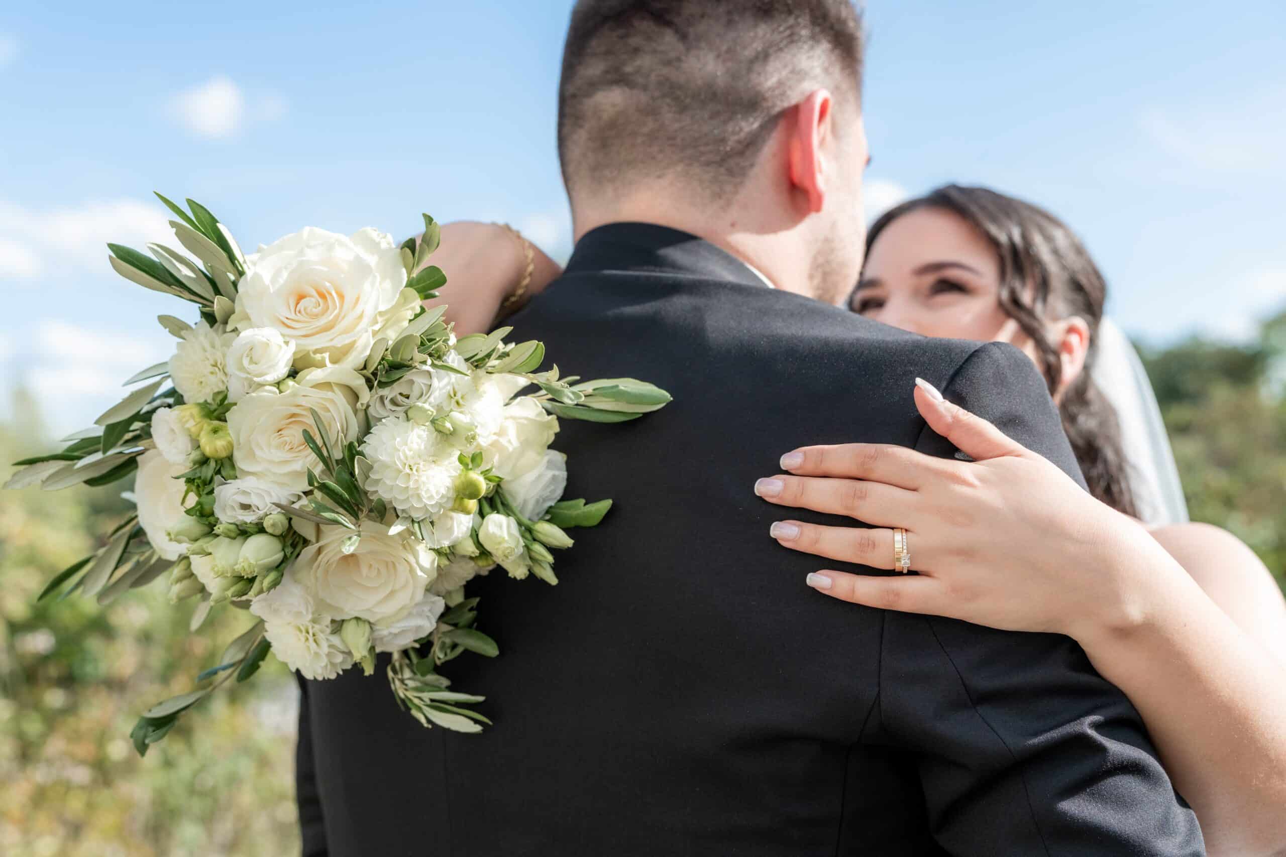 Brautstrauß und Umarmung bei sonniger Hochzeit