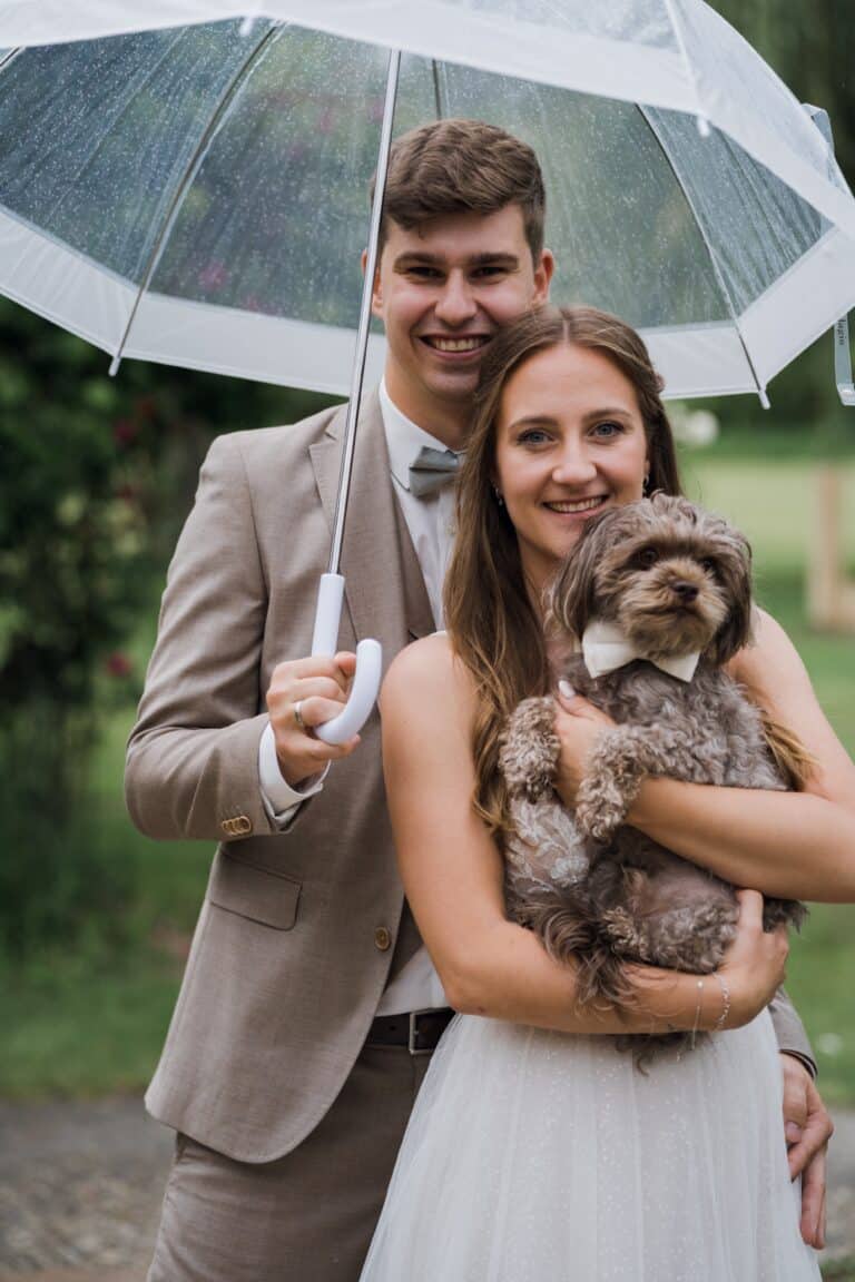 01853-florian-knusper-hochzeitsfotograf-wuerzburg-paar-mit-hund-im-garten-Hotel Freihof Prichsenstadt