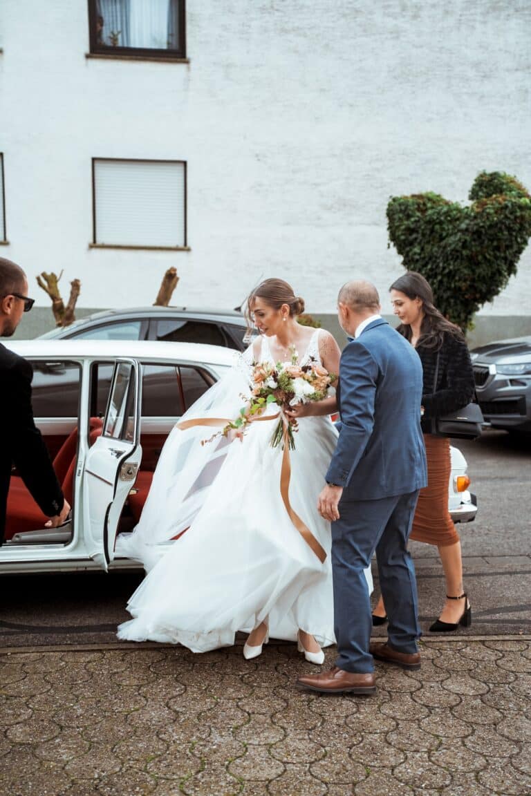 01857-florian-knusper-hochzeitsfotograf-wuerzburg-brautpaar-steigt-aus-auto-Schloss Zeilitzheim