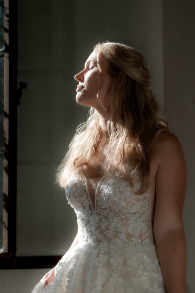 Braut in Spitzenkleid im Sonnenlicht Kloster Bronnbach