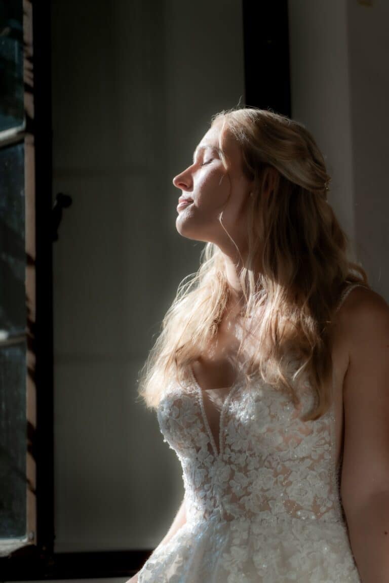 01957-florian-knusper-hochzeitsfotograf-wuerzburg-braut-am-fenster-Kloster Bronnbach