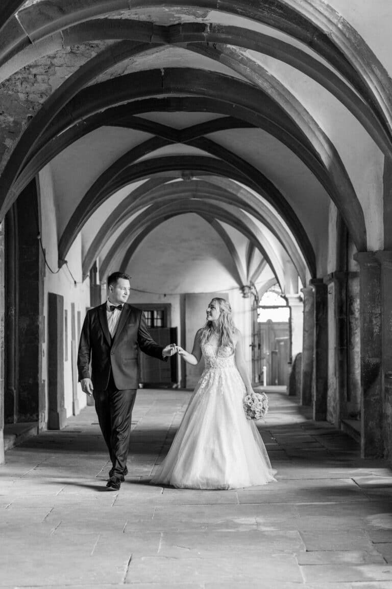 01996-2-florian-knusper-hochzeitsfotograf-wuerzburg-brautpaar-im-gewoelbegang-Kloster Bronnbach