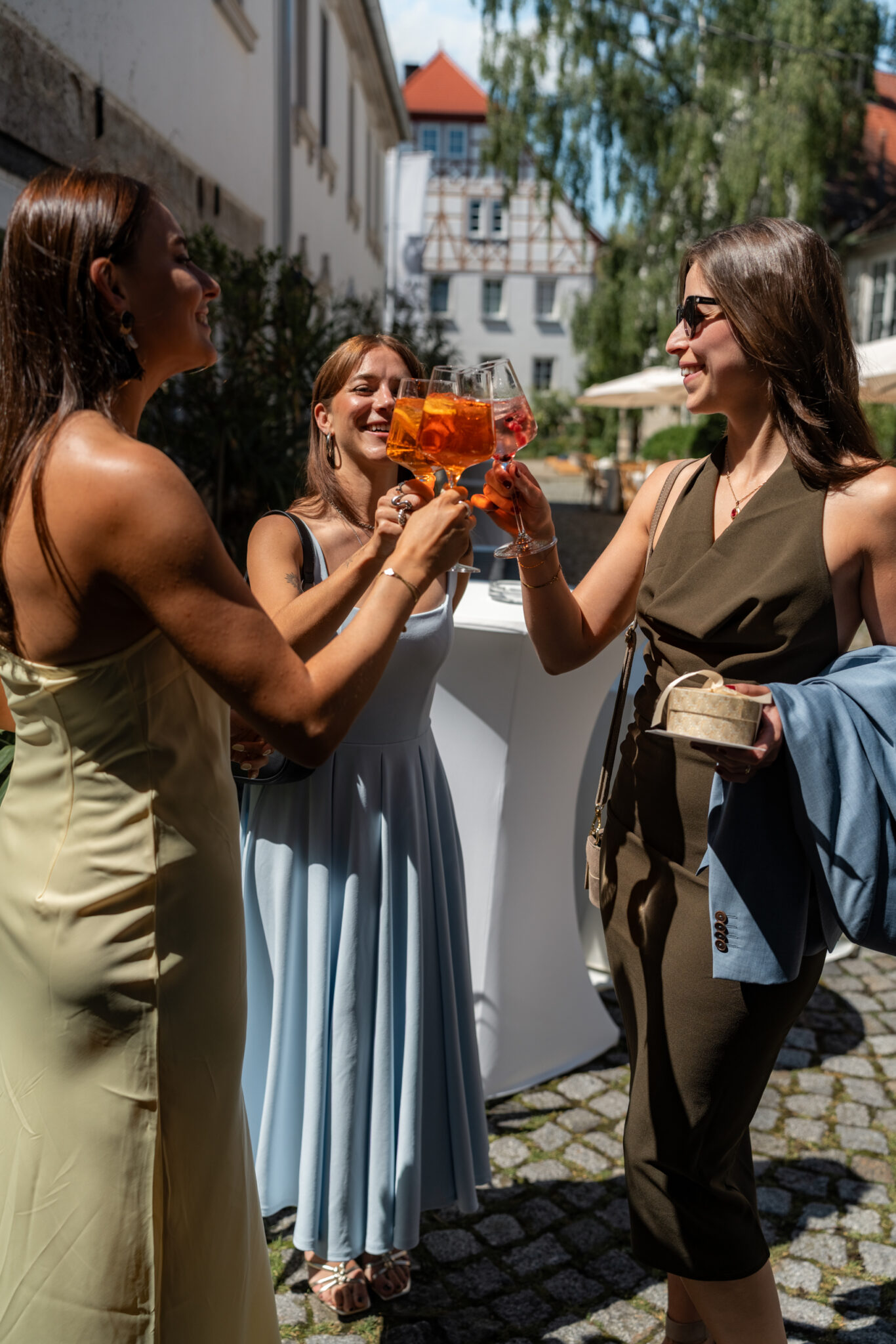Gäste stoßen beim Hochzeitsempfang im Hof an