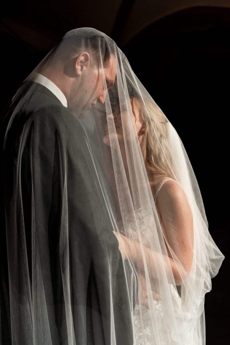 02192-florian-knusper-hochzeitsfotograf-wuerzburg-brautpaar-unter-schleier-Kloster Bronnbach