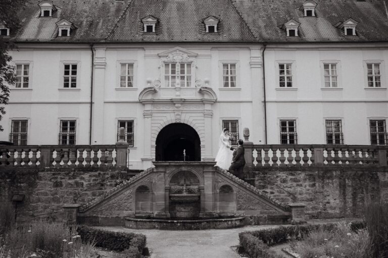 02230-2-florian-knusper-hochzeitsfotograf-wuerzburg-brautpaar-vor-schloss-Schloss Oberschwarzach