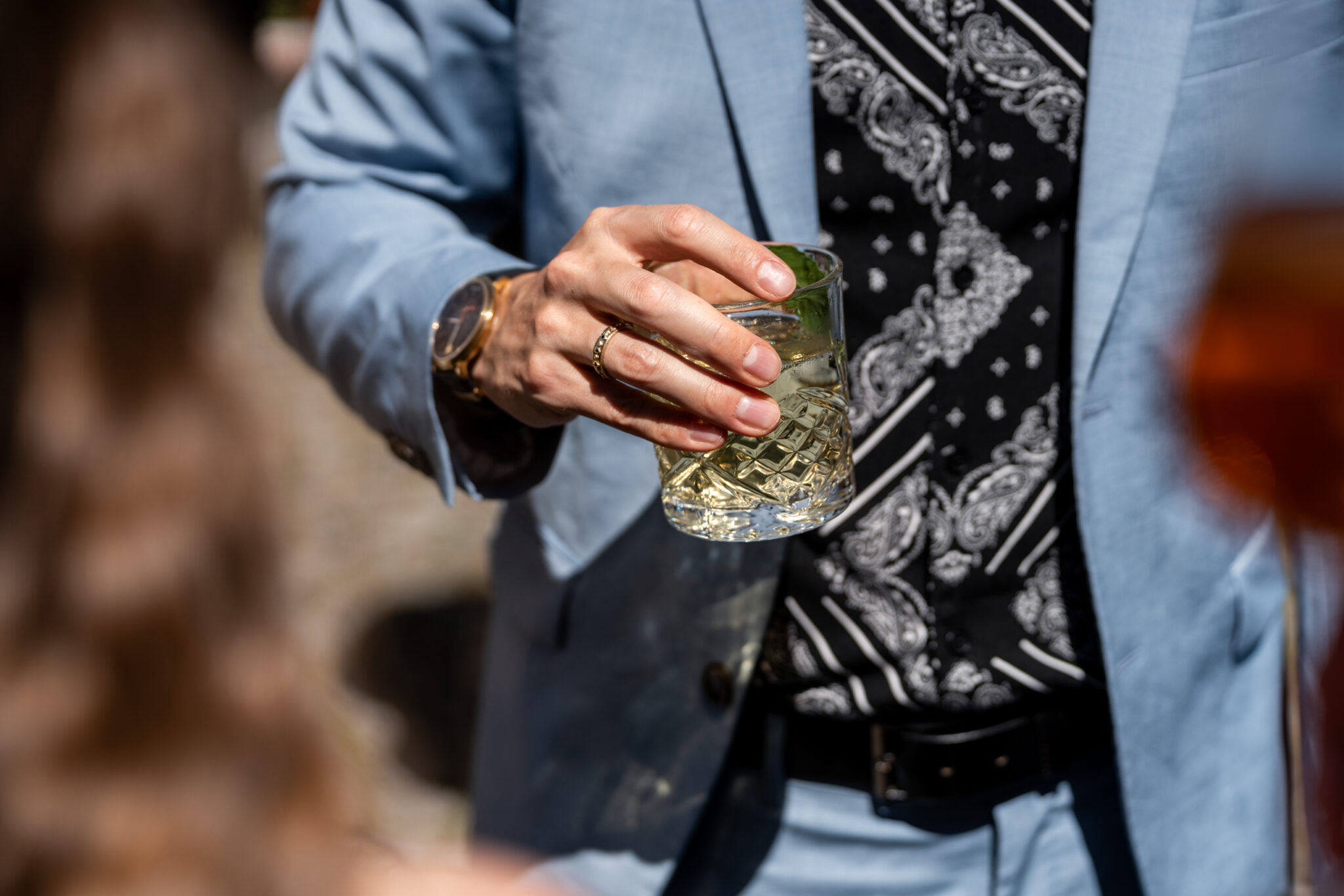 Hochzeitsgast hält Cocktail beim Empfang im Freien