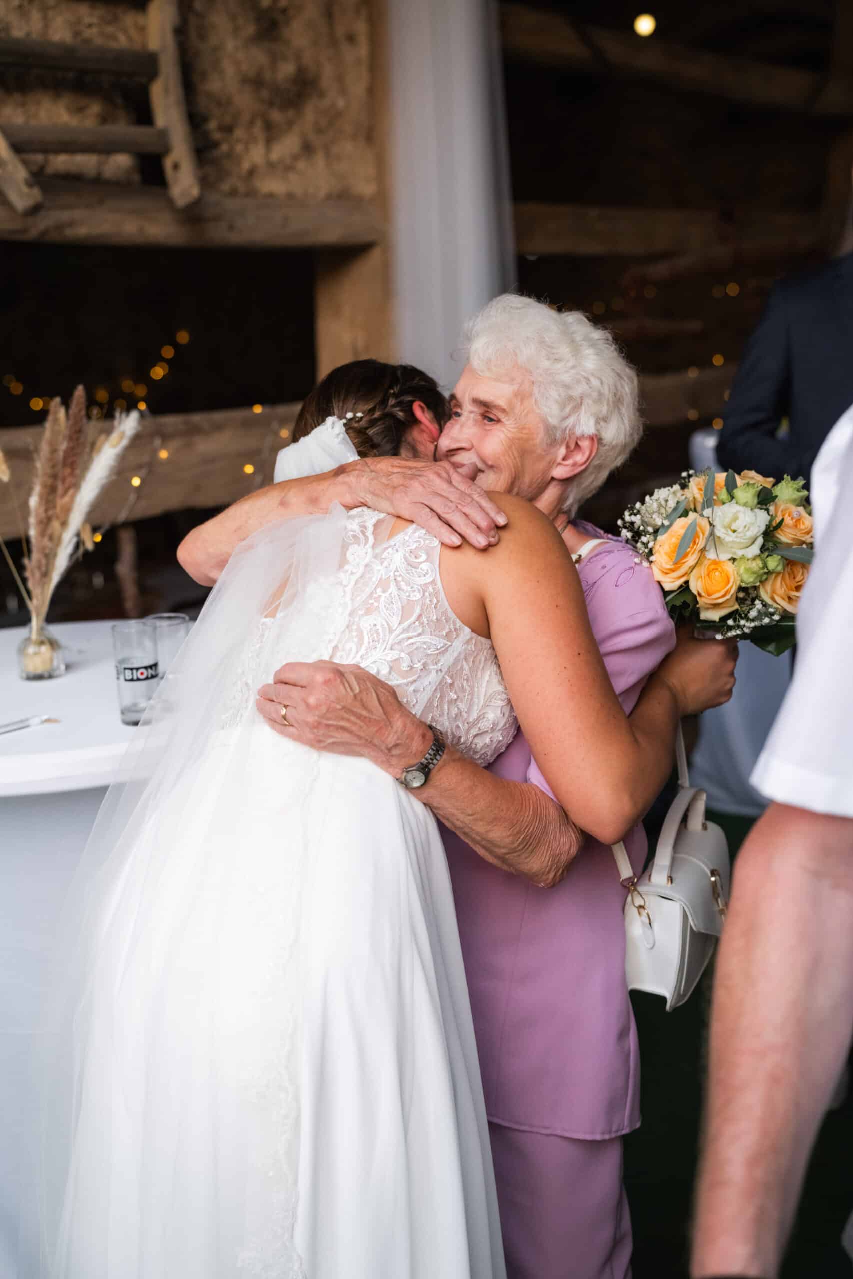 02270-florian-knusper-hochzeitsfotograf-wuerzburg-braut-umarmt-aeltere-dame