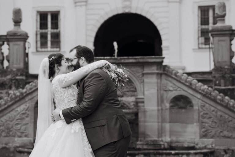 02356-2-florian-knusper-hochzeitsfotograf-wuerzburg-brautpaar-vor-schloss-treppe-Schloss Oberschwarzach