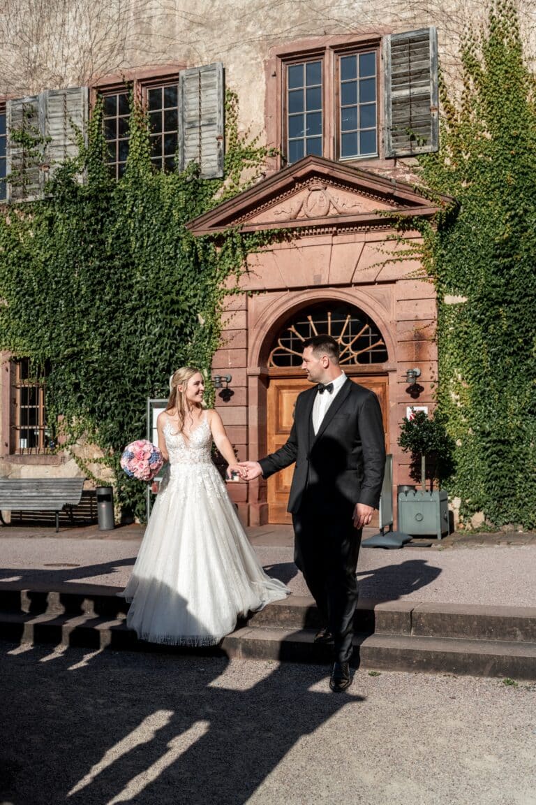 02398-florian-knusper-hochzeitsfotograf-wuerzburg-brautpaar-vor-historischem-gebaeude-Kloster Bronnbach