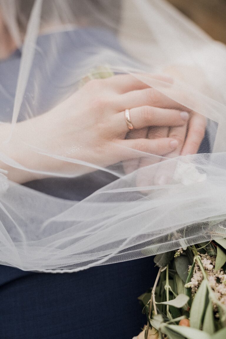 02492-florian-knusper-hochzeitsfotograf-wuerzburg-haende-mit-brautstrauss-unter-schlei-Schloss Oberschwarzach