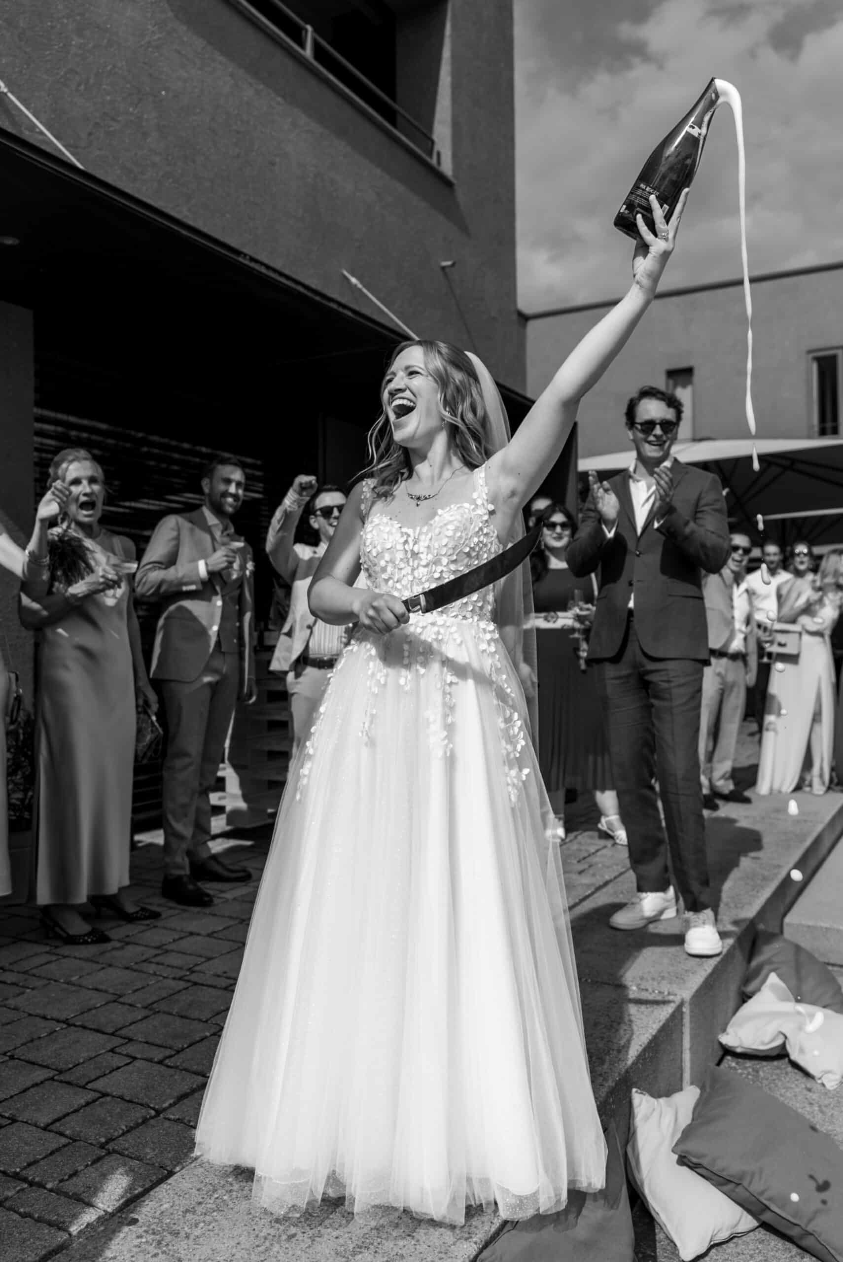 02514-florian-knusper-hochzeitsfotograf-wuerzburg-braut-mit-sektflasche-Schlosshotel Steinburg