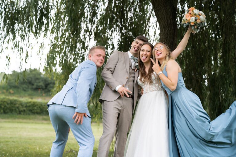 02601-florian-knusper-hochzeitsfotograf-wuerzburg-brautpaar-mit-freunden-im-garten-Hotel Freihof Prichsenstadt