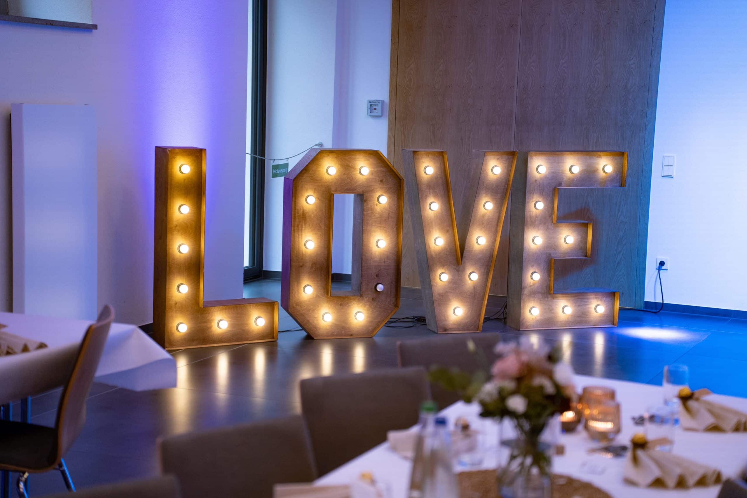 Leuchtbuchstaben LOVE bei Hochzeitsdeko im Saal