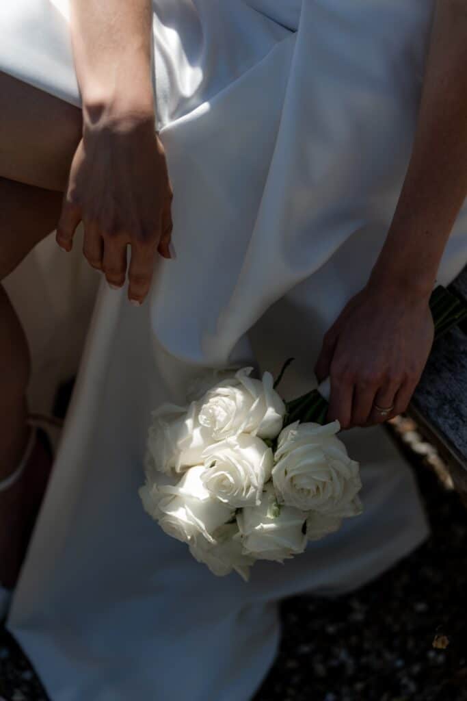 Weiße Rosen im Brautstrauß auf Hochzeitskleid, Villa Oriental