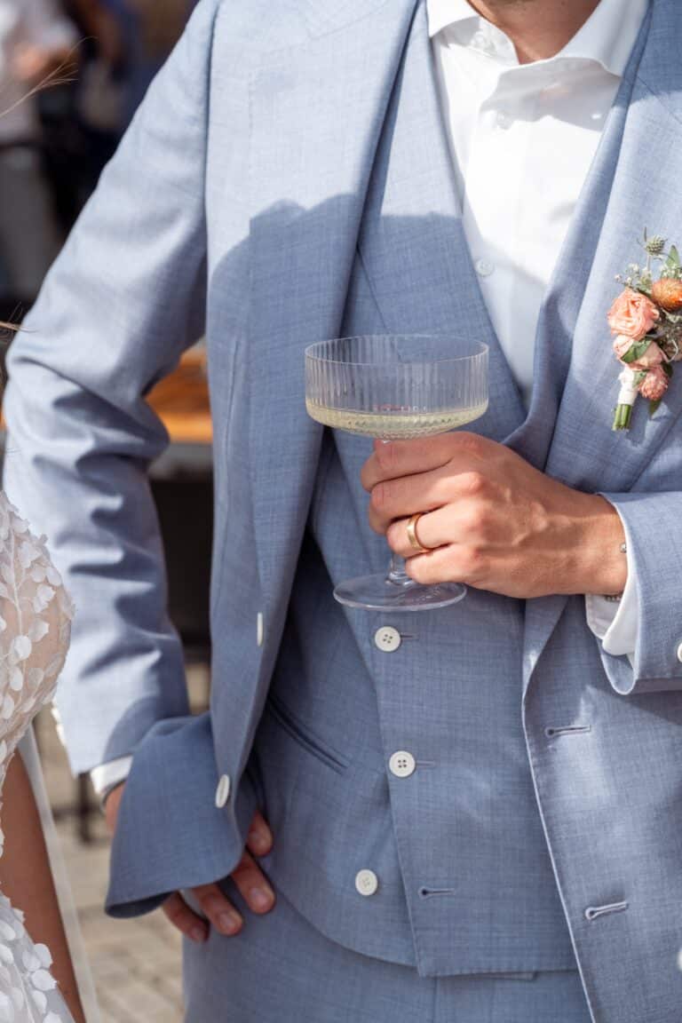 02921-florian-knusper-hochzeitsfotograf-wuerzburg-mann-im-anzug-mit-sektglas-Schlosshotel Steinburg Wuerzburg