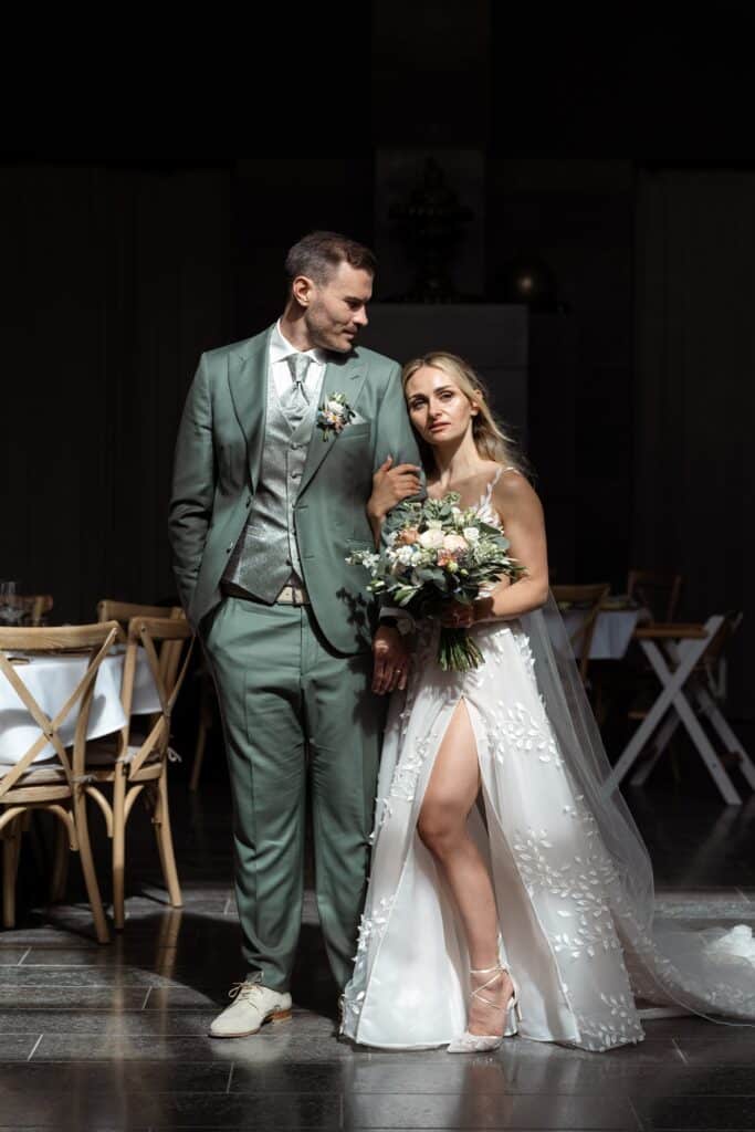 Brautpaar posiert elegant im Hochzeitssaal
