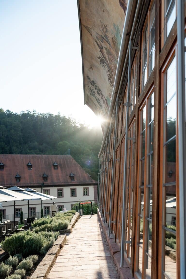 03074-florian-knusper-hochzeitsfotograf-wuerzburg-garten-mit-gebaeude-im-hintergrund-Kloster Bronnbach