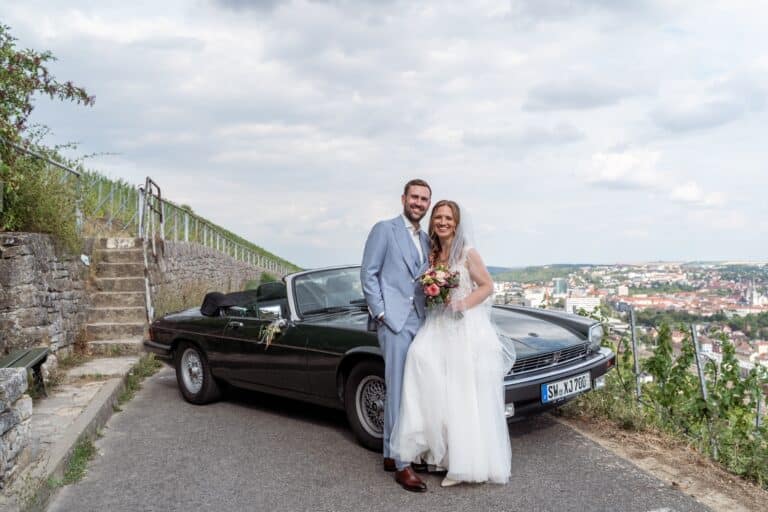 03187-florian-knusper-hochzeitsfotograf-wuerzburg-brautpaar-und-auto-auf-landstrasse-Schlosshotel Steinburg Wuerzburg