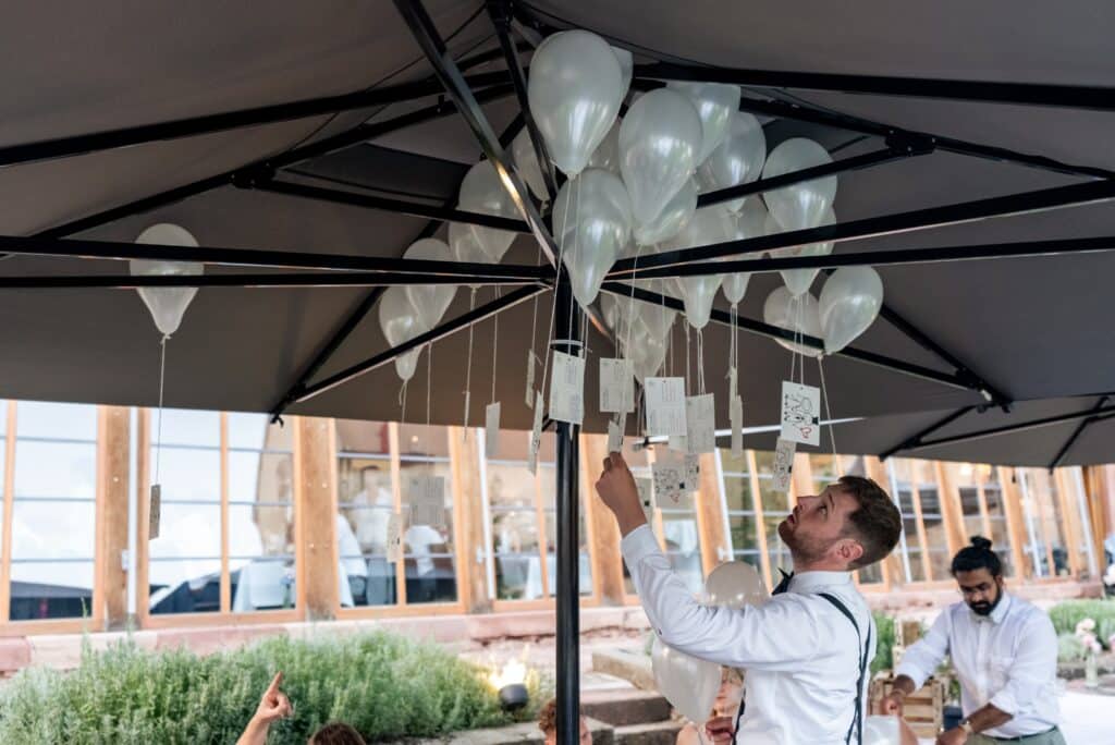 Hochzeitsballons unter Pavillon befestigen