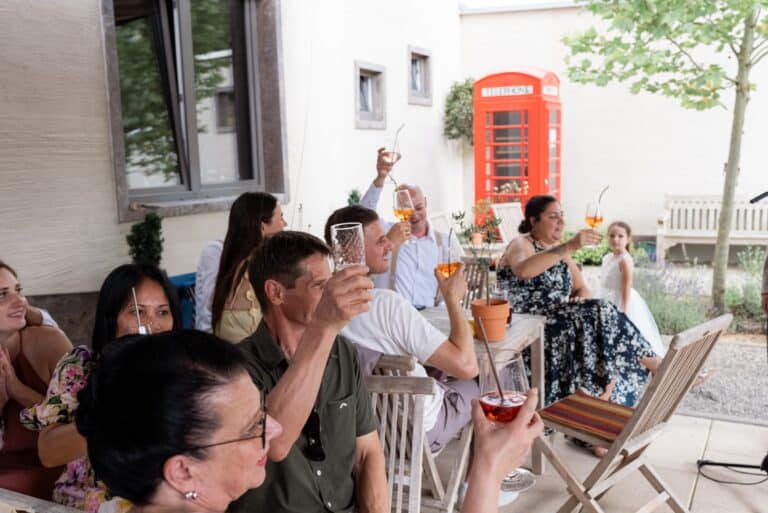 03546-florian-knusper-hochzeitsfotograf-wuerzburg-gruppe-von-gaesten-toasten-villa-oriental