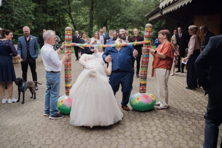03564-florian-knusper-hochzeitsfotograf-wuerzburg-limbo-spiel-bei-hochzeit-Schloss Oberschwarzach