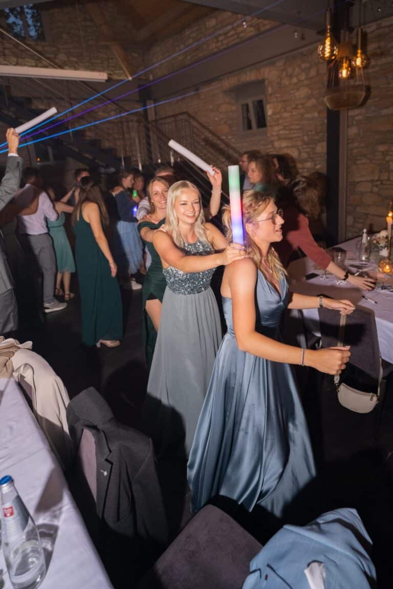 03624-florian-knusper-hochzeitsfotograf-wuerzburg-feiernde-gaeste-mit-lichtern-Hotel Freihof Prichsenstadt