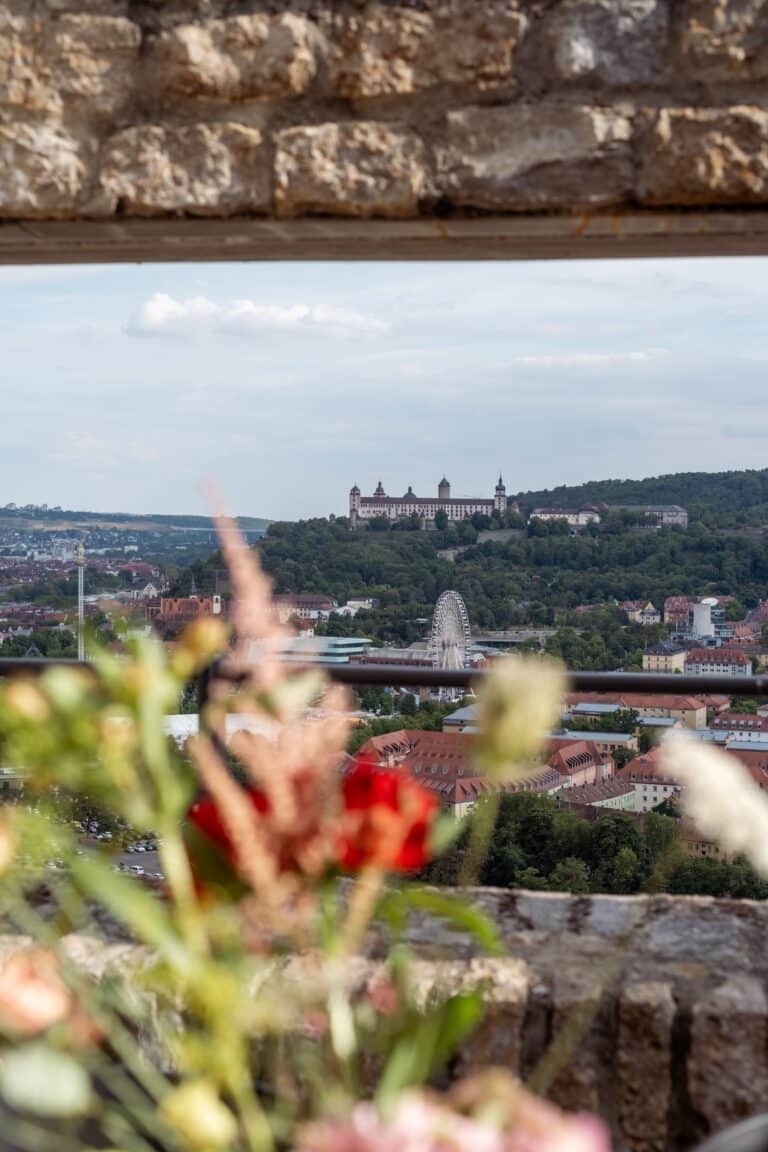 03787-florian-knusper-hochzeitsfotograf-wuerzburg-blick-auf-stadt-von-blumen-gerahmt-Schlosshotel Steinburg Wuerzburg