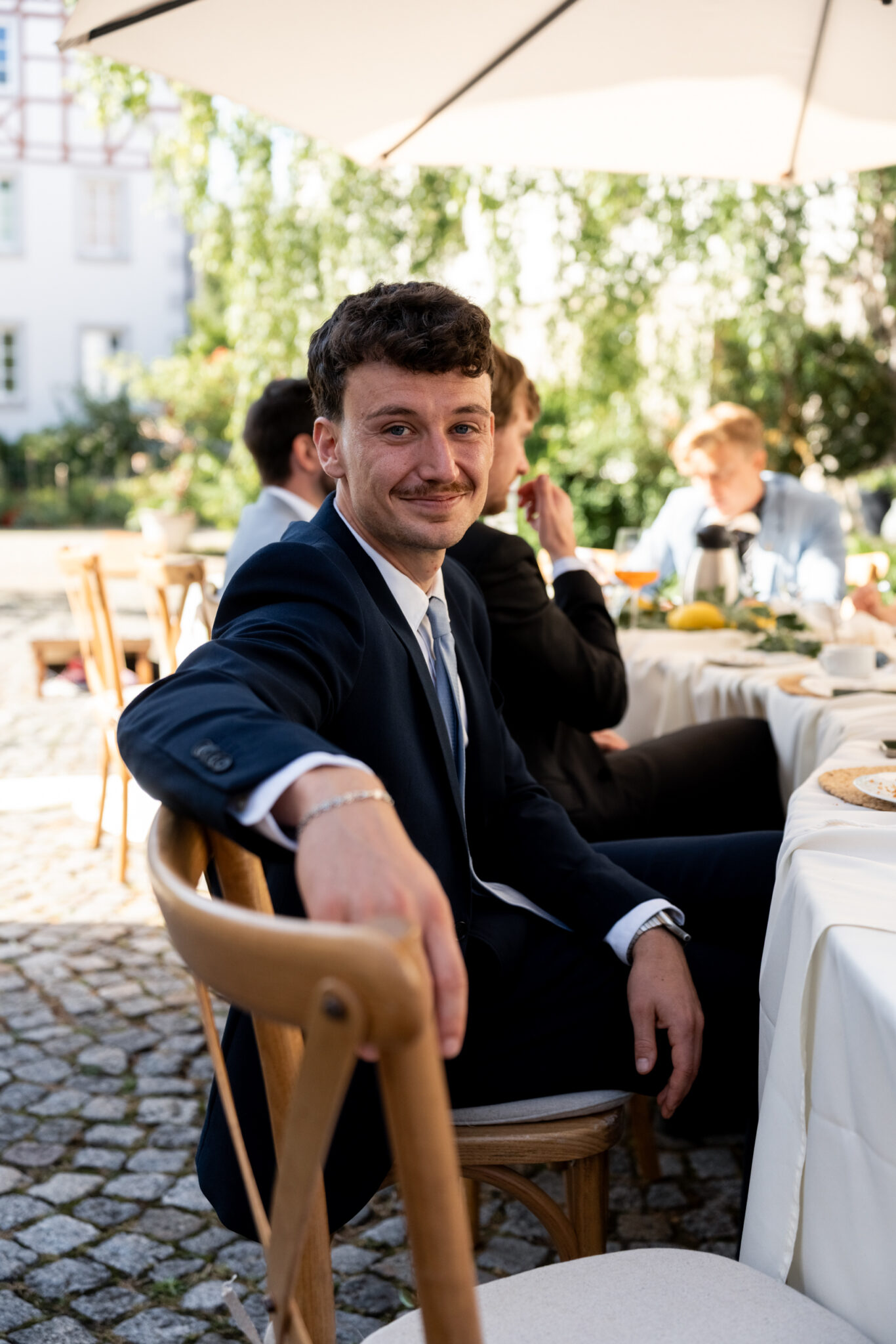 Hochzeitsgäste im Garten an festlich gedecktem Tisch