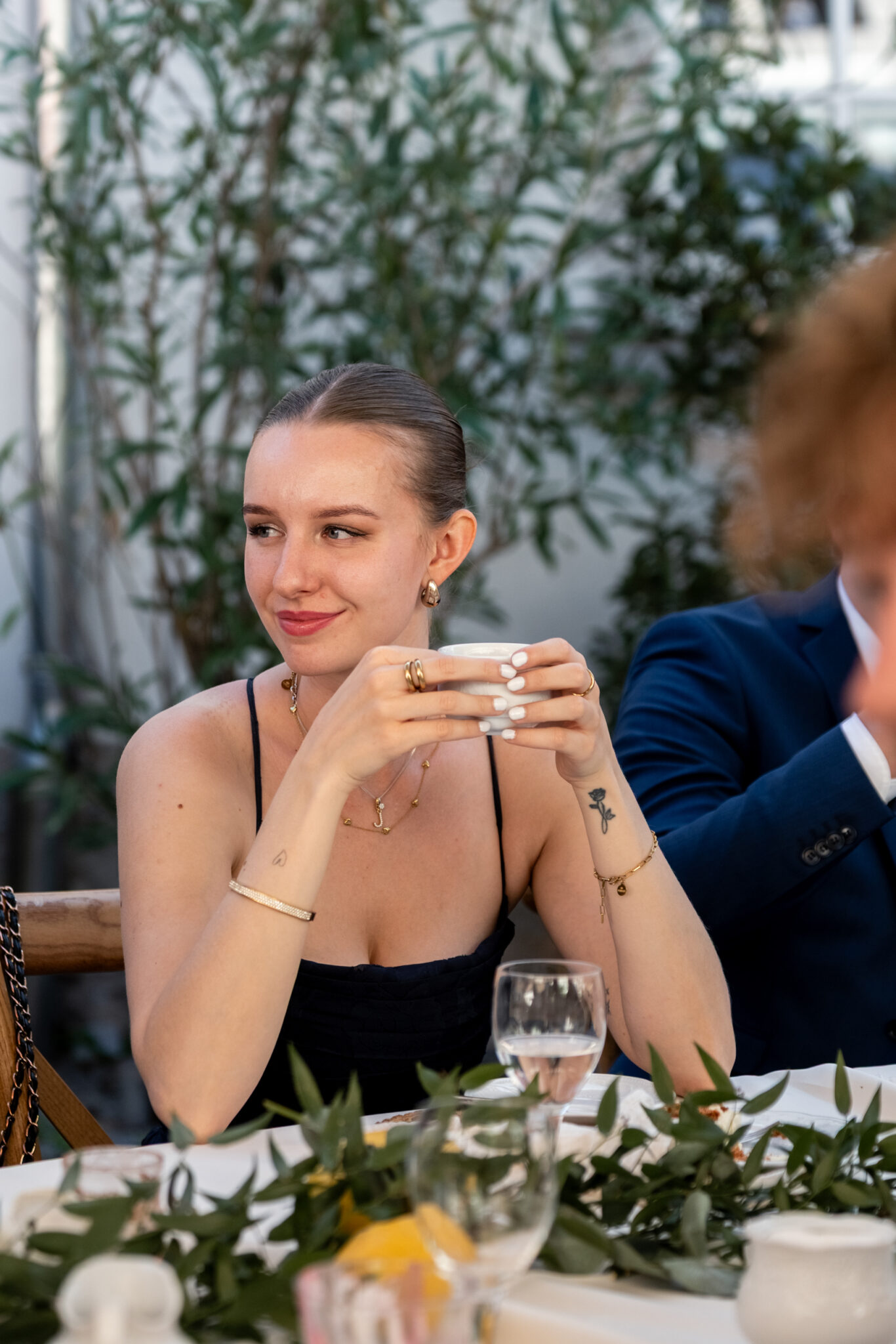 Gast mit Kaffeetasse am Hochzeitstisch im Garten