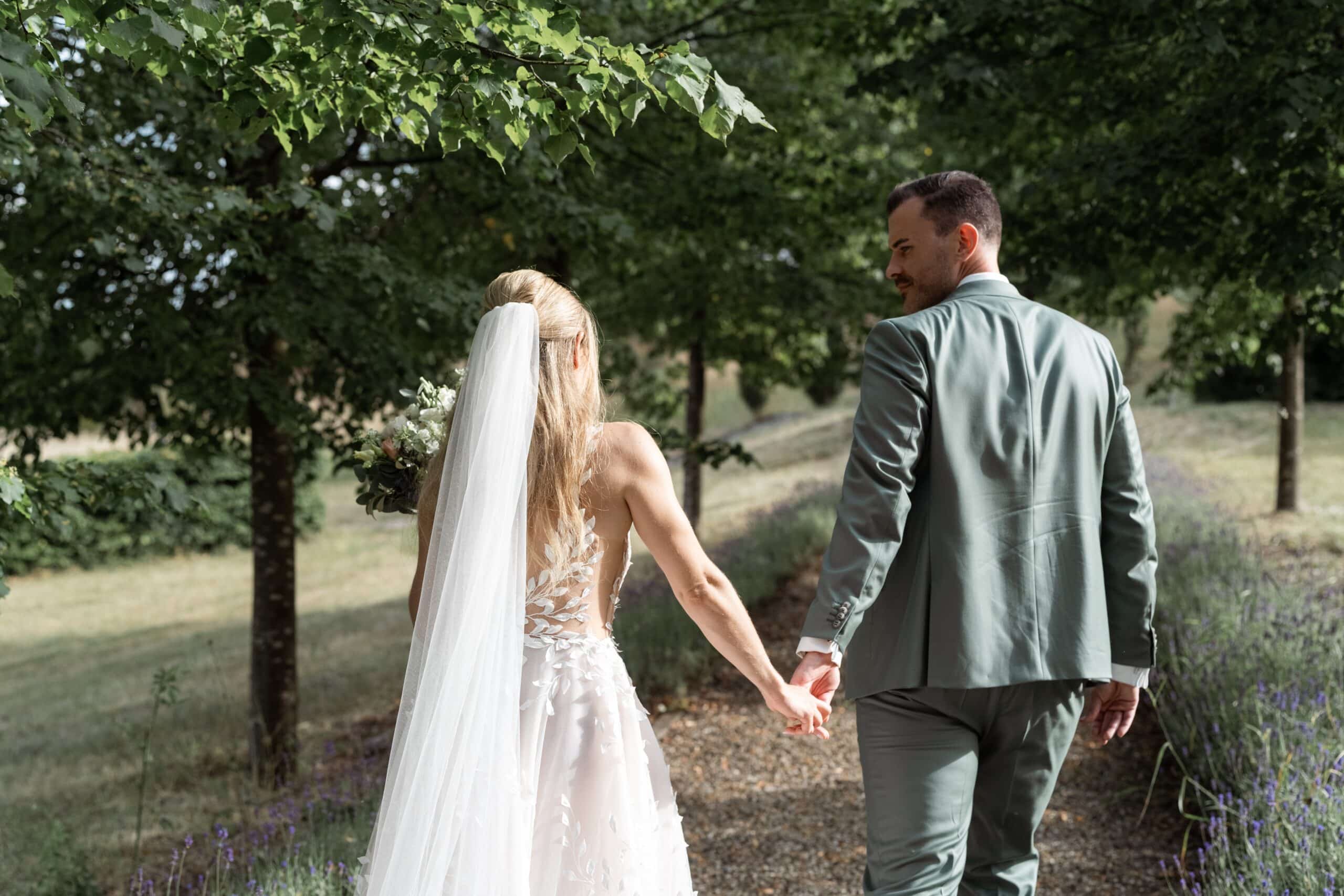 Brautpaar Hand in Hand im grünen Garten
