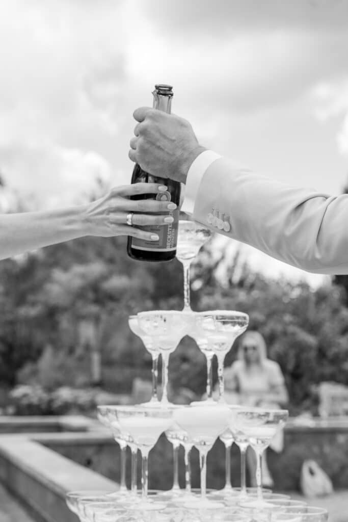Sektflaschenöffnung vor Champagner-Pyramide