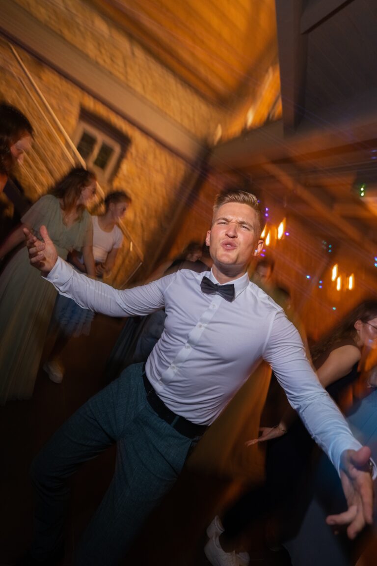 04001-florian-knusper-hochzeitsfotograf-wuerzburg-tanzende-gaeste-im-festsaal-Hotel Freihof Prichsenstadt