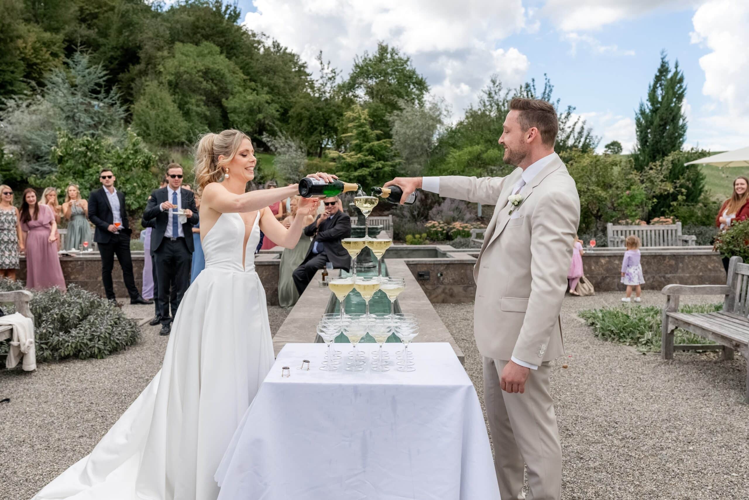 Styled shooting vs echte hochzeit Hochzeitspaar gießt Sektpyramide im Garten auf