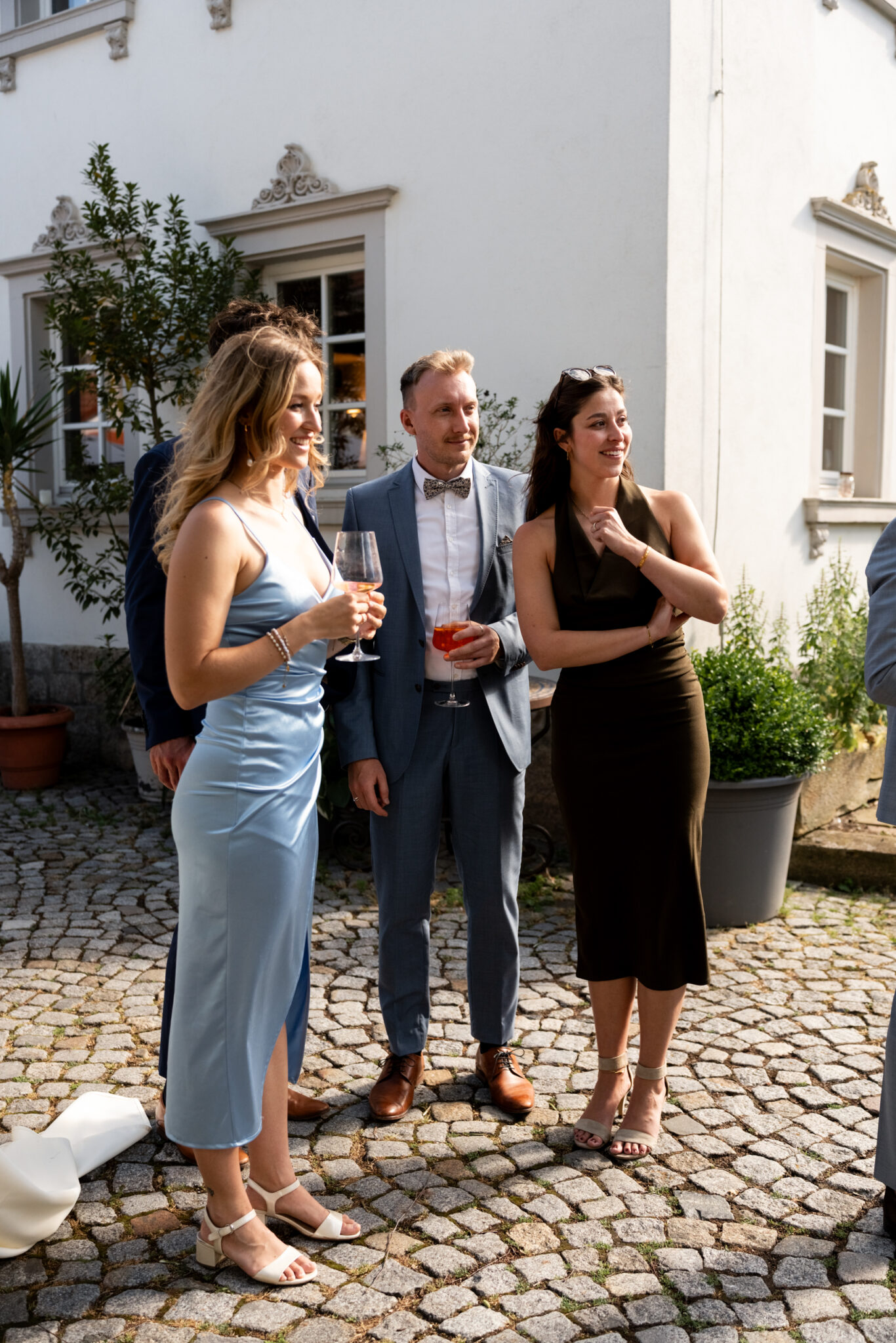 Hochzeitsgäste beim Sektempfang im Innenhof