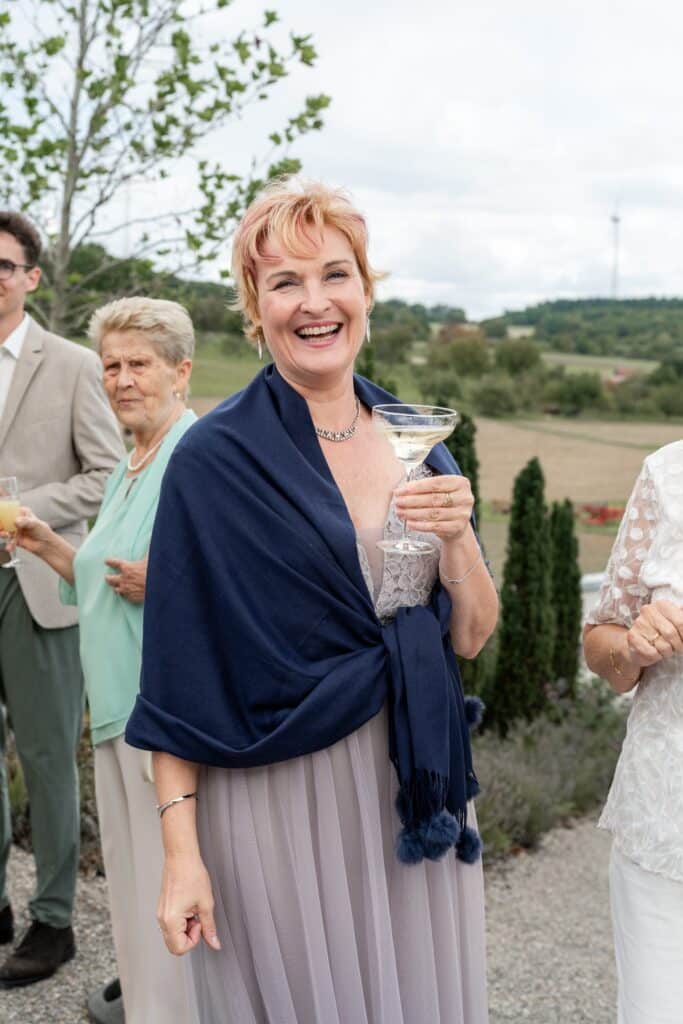 Elegante Hochzeitsgäste im Freien feiern.