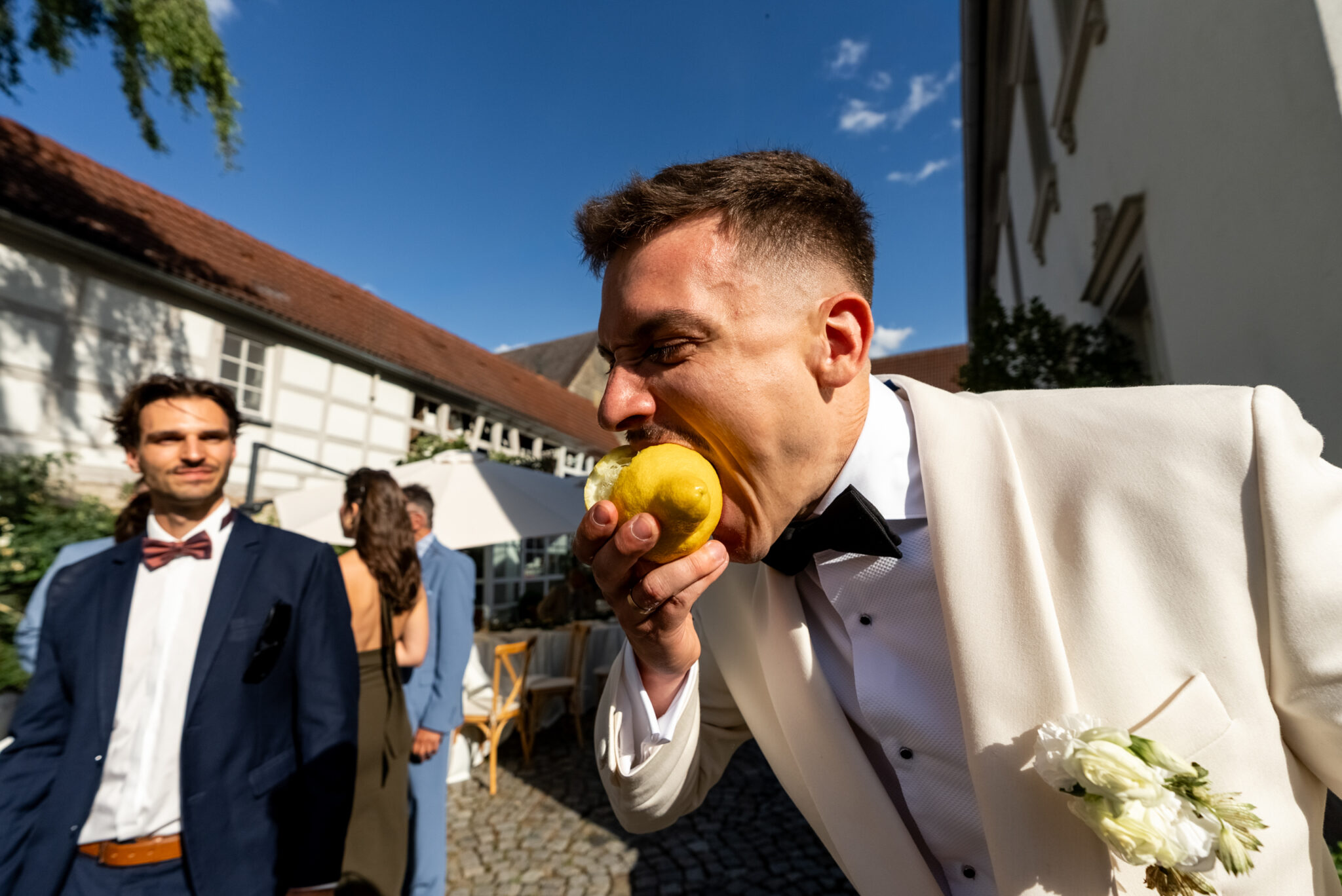 Bräutigam isst Obst beim Empfang im Innenhof