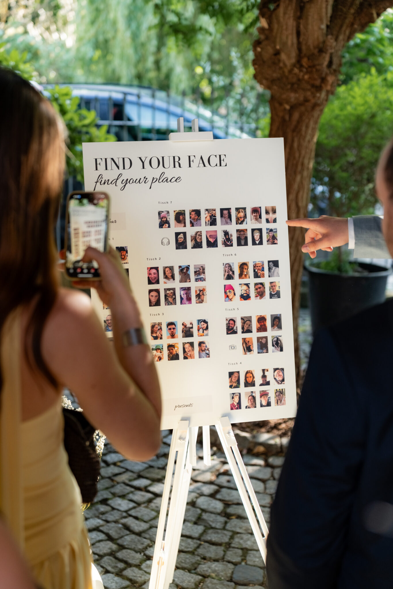 Hochzeitlicher Sitzplan mit Gästefotos im Garten