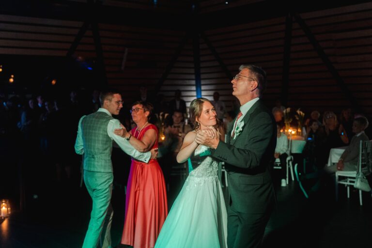 04215-florian-knusper-hochzeitsfotograf-wuerzburg-tanzendes-brautpaar-mit-gaesten-Dänischer Pavillon